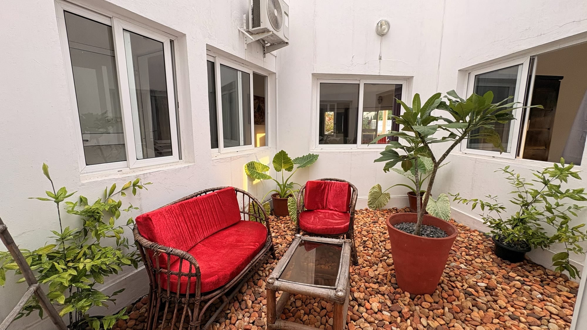 Coin salon extérieur et fauteuils dans la cour de Maison Stella